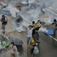 Protesters walk through tear gas used by riot police against protesters after thousands of people blocked a main road at the financial central district in Hong Kong, Sunday, Sept. 28, 2014